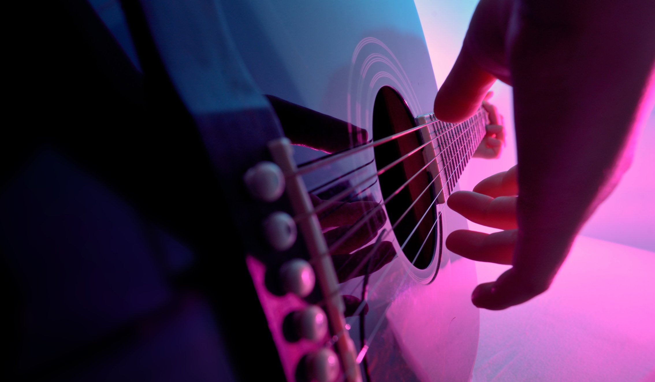 Acoustic guitar played by a girl and colorful lights